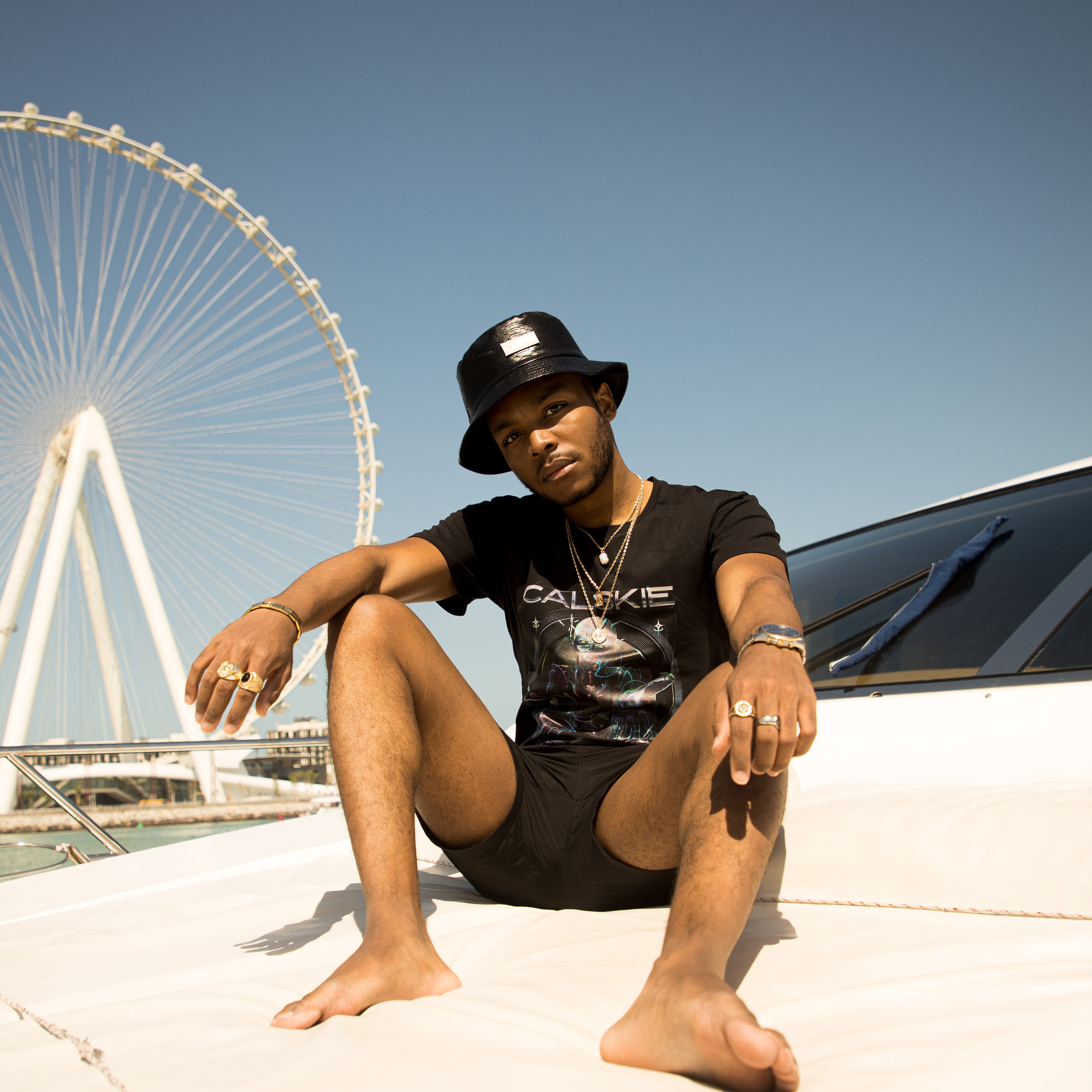 An image showing the black crocodile pattern leather bucket hat by Calskie, featuring the gold Calskie logo on the front.