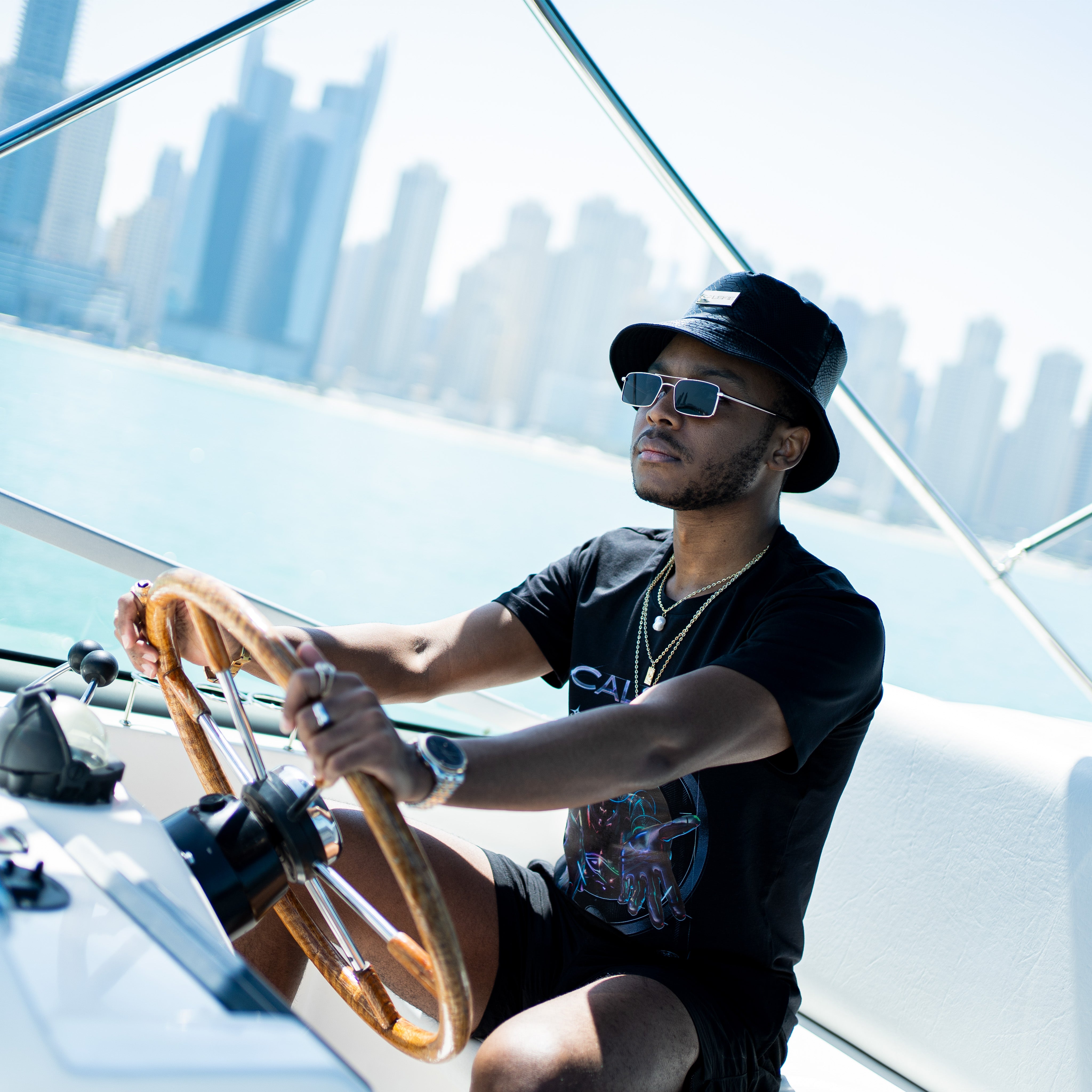 An image showing the black crocodile pattern leather bucket hat by Calskie, featuring the gold Calskie logo on the front.